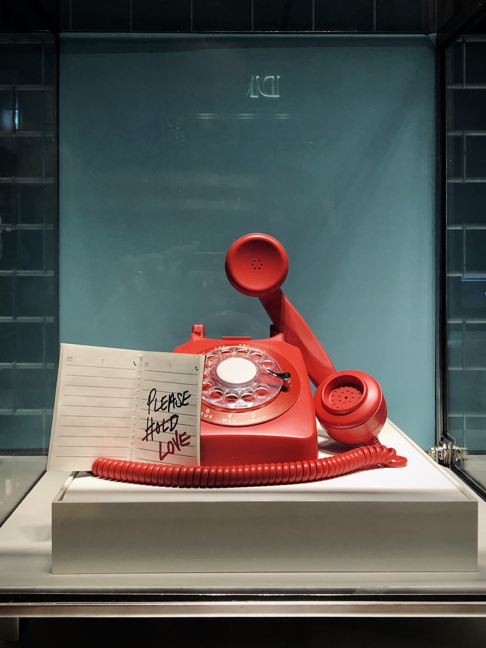 Téléphone à cadran rouge et blanc sur table blanche