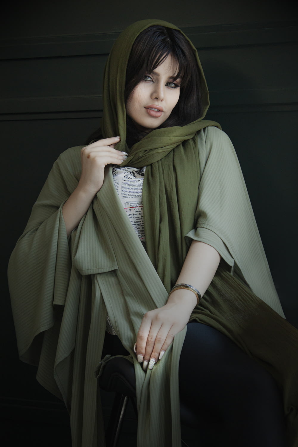 femme en hijab vert assise sur une chaise noire