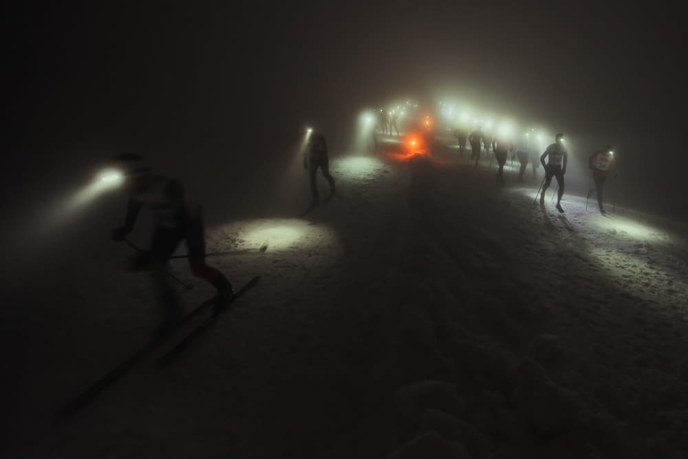 people walking on snow covered field during night time