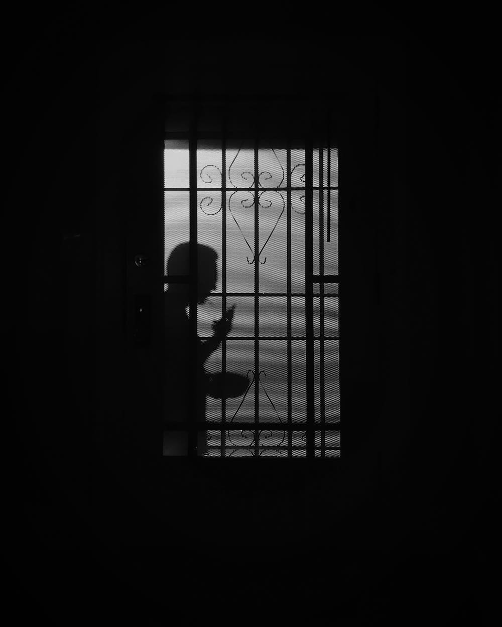 silhouette of person standing on window