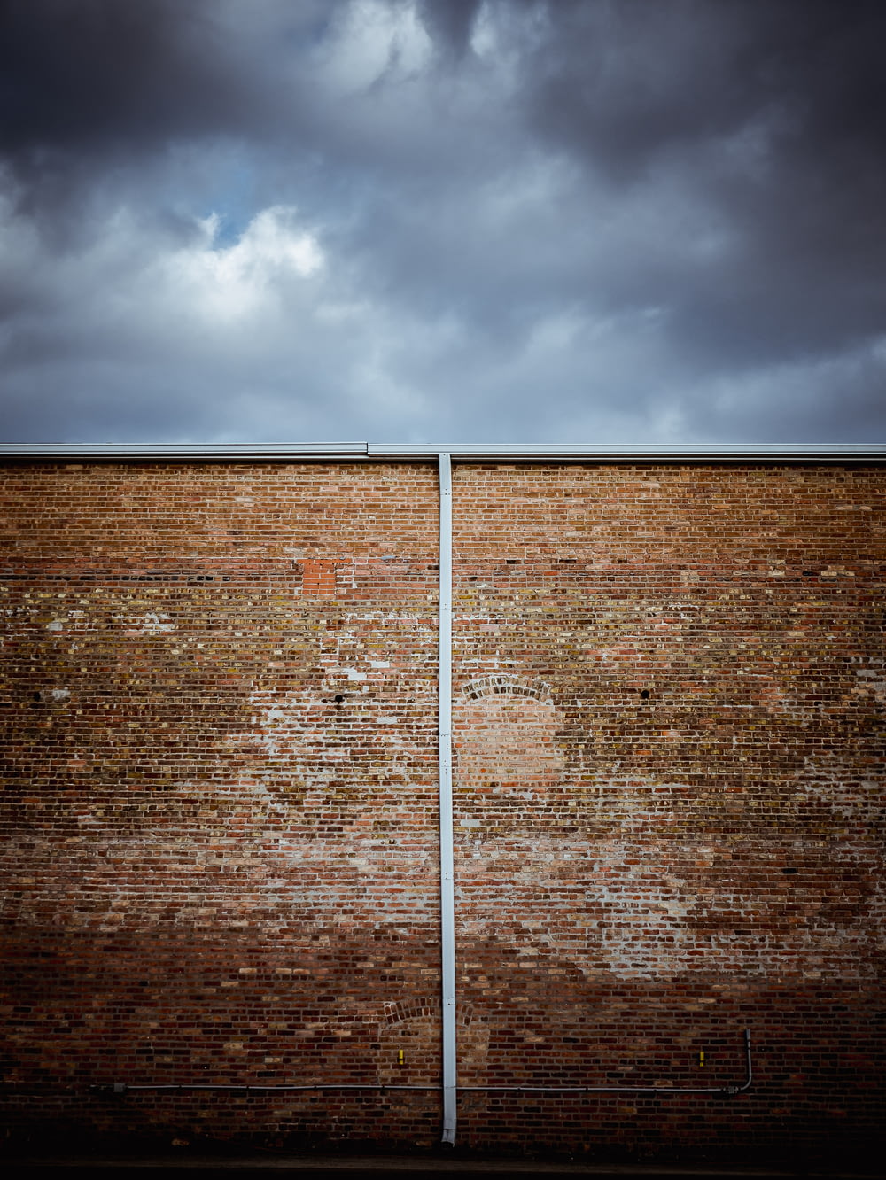 brown brick wall under cloudy sky during daytime