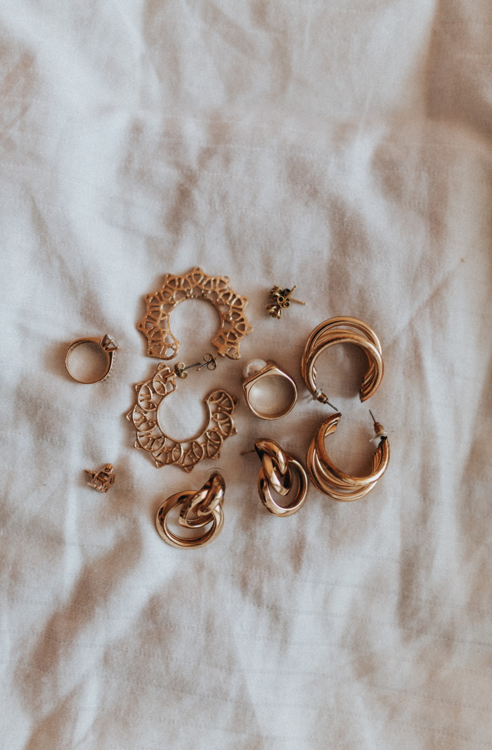 gold heart shaped earrings on white textile