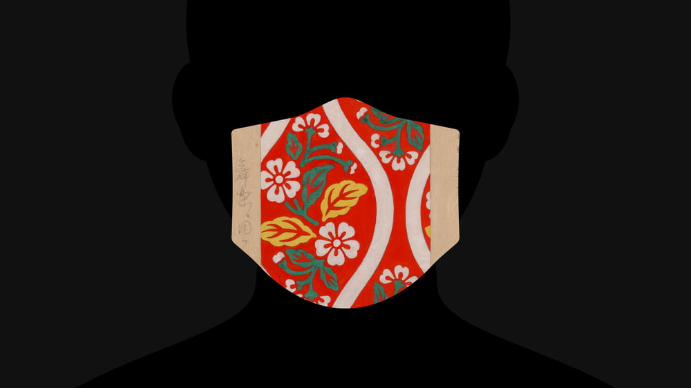 a person wearing a red mask with flowers on it