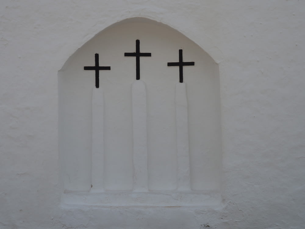 white cross on white concrete wall