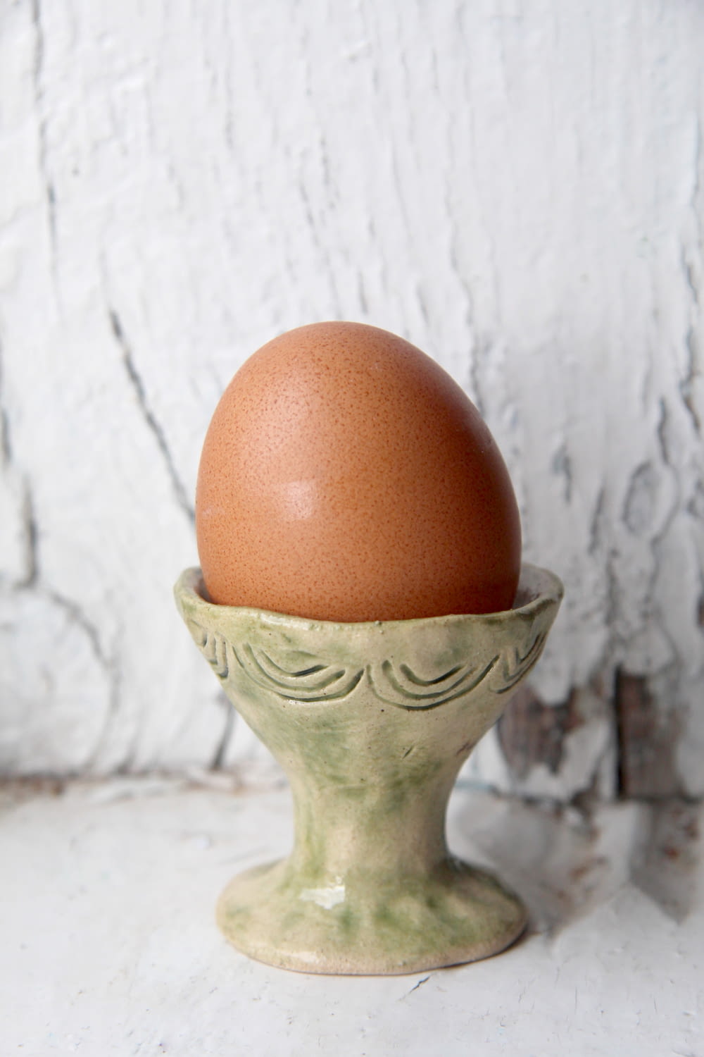 brown egg on gray ceramic vase