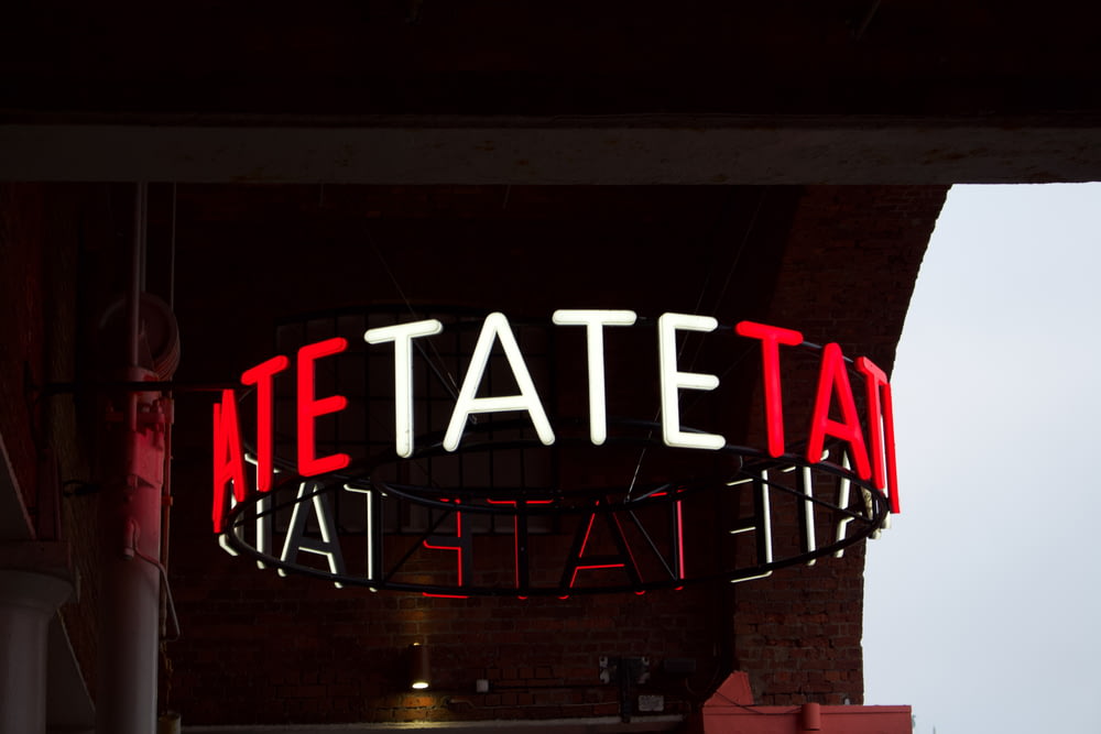 a neon sign that says netateat at the top of a building