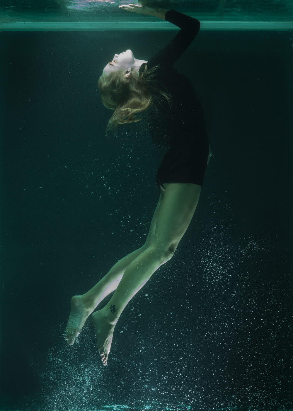 woman in black shirt and green shorts in water