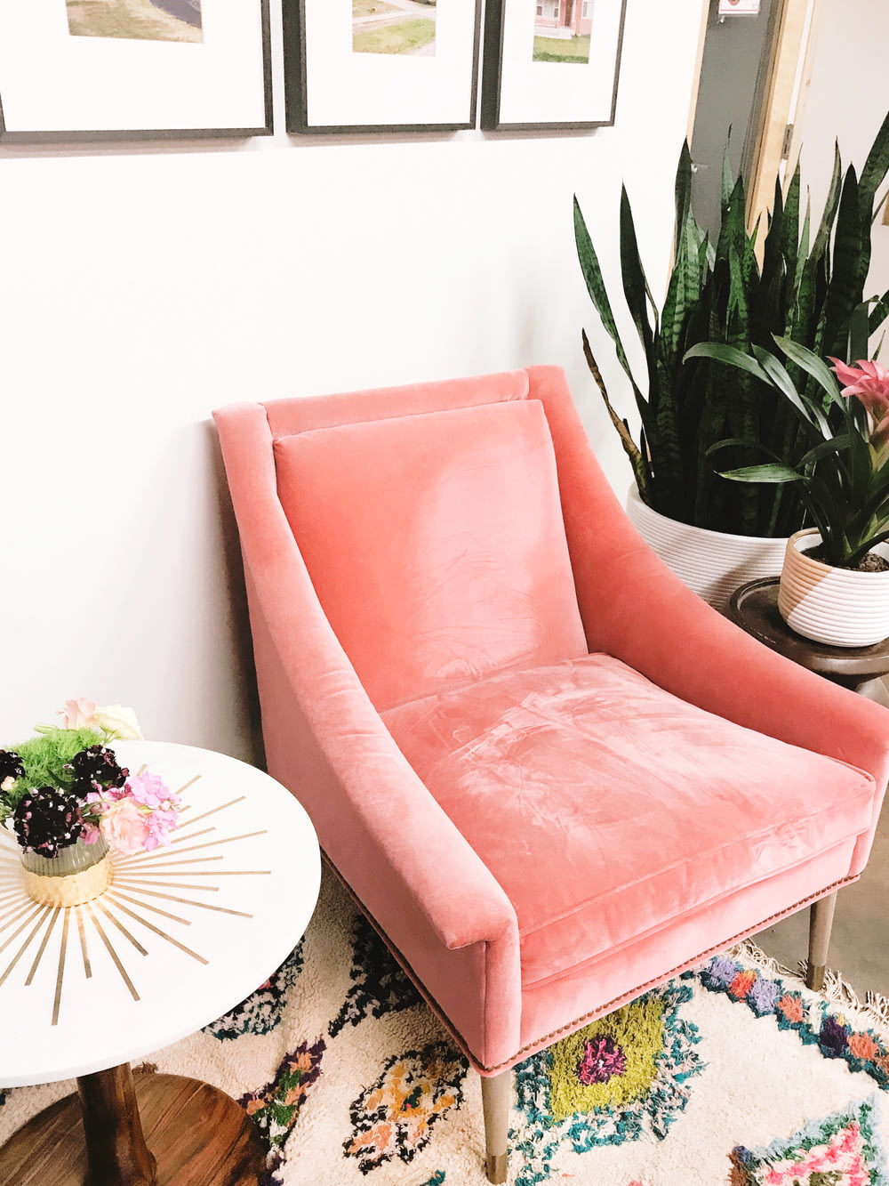 흰색 원탁 옆에 분홍색 소파 의자