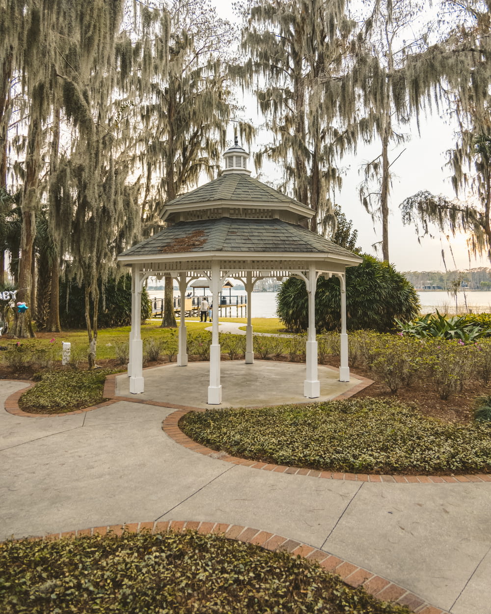 white and black gazebo surrounded by trees during daytime