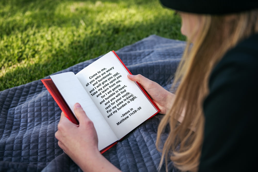 femme en chemise à manches longues grise livre de lecture