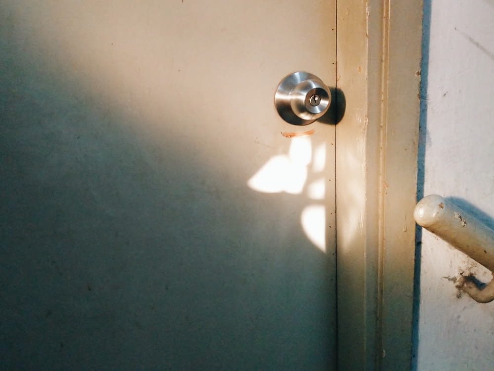 silver door knob on blue wooden door