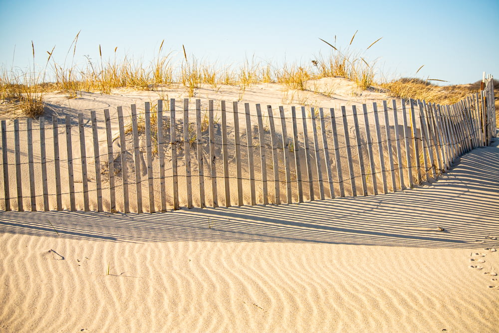 gray wooden fence on brown sand