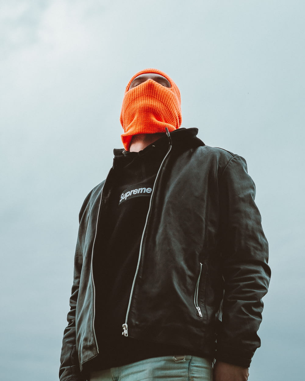 Homme en veste noire et casquette en tricot orange