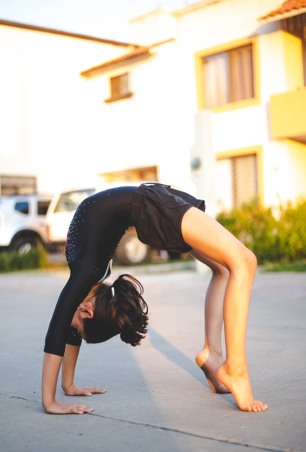 woman in black tank top and black leggings doing yoga during daytime