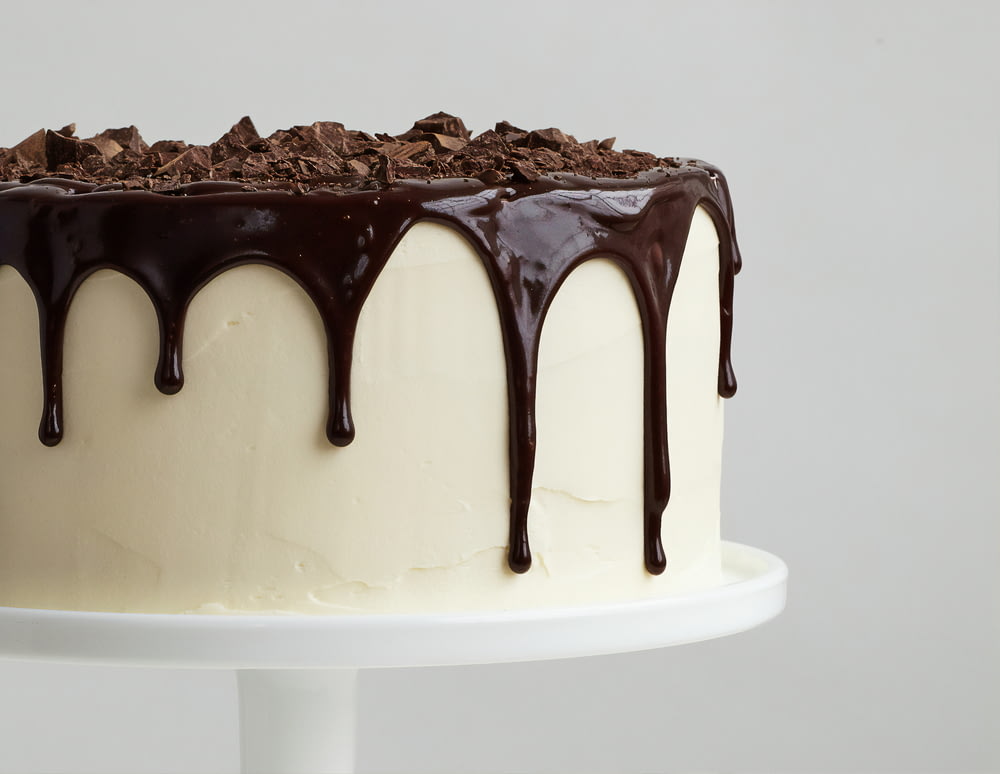 weißer Kuchen mit Schokoladensirup auf weißem Keramikteller