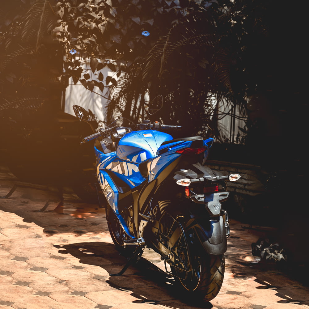 blue sports bike parked on brown dirt