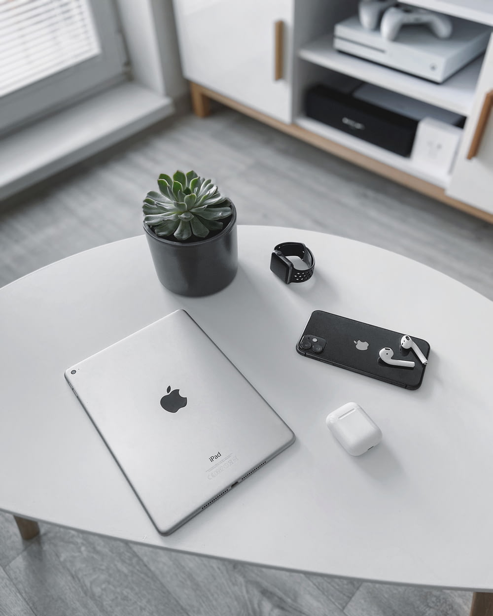 MacBook argenté à côté de la souris magique Apple blanche et de la plante verte sur une table blanche