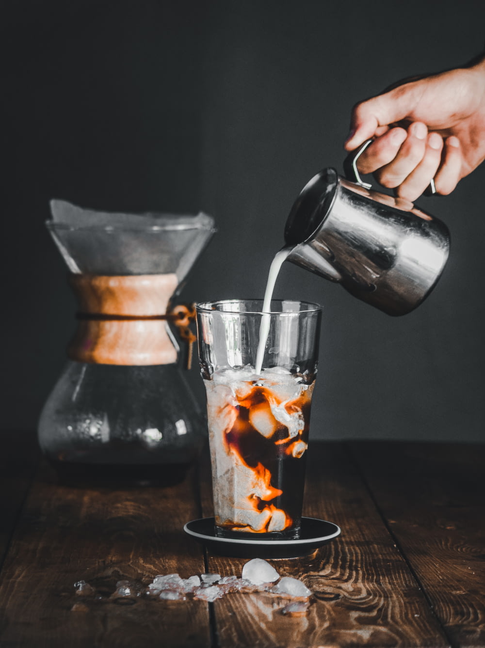 person pouring coffee on clear glass mug