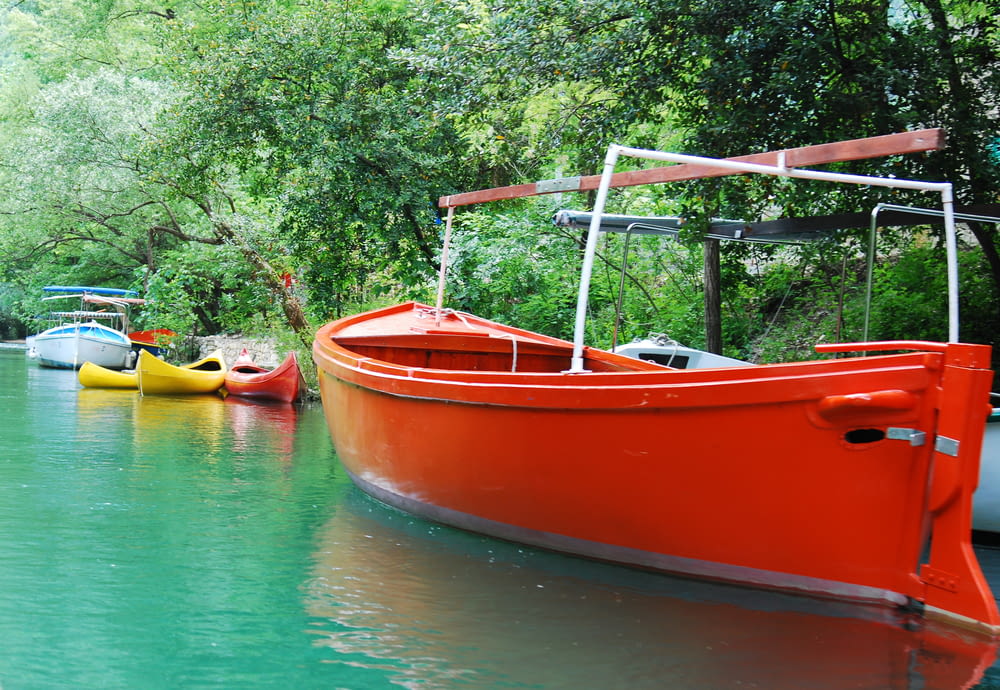 red and yellow boat on body of water during daytime