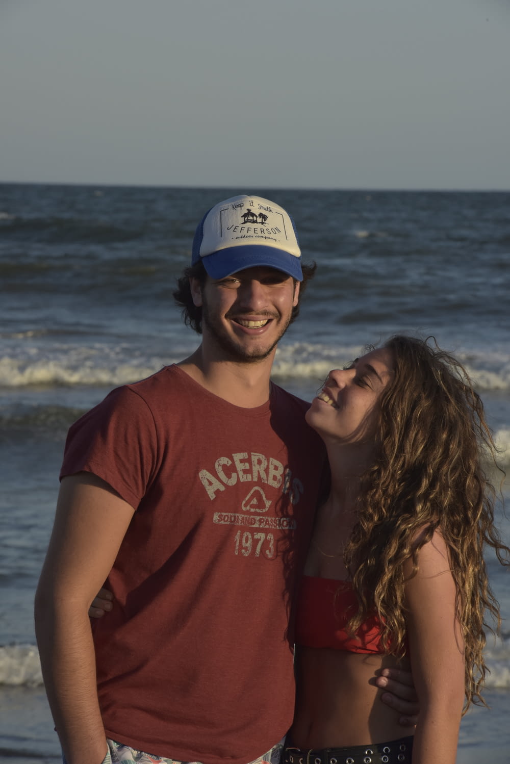 homme et femme souriant près de la mer pendant la journée