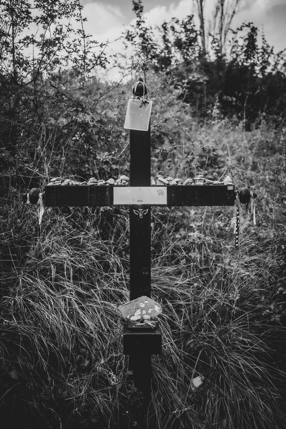 森の真ん中にある十字架のグレースケール写真