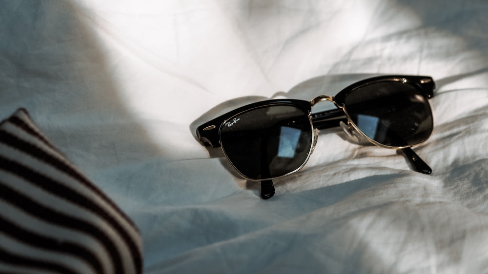 black framed sunglasses on white textile