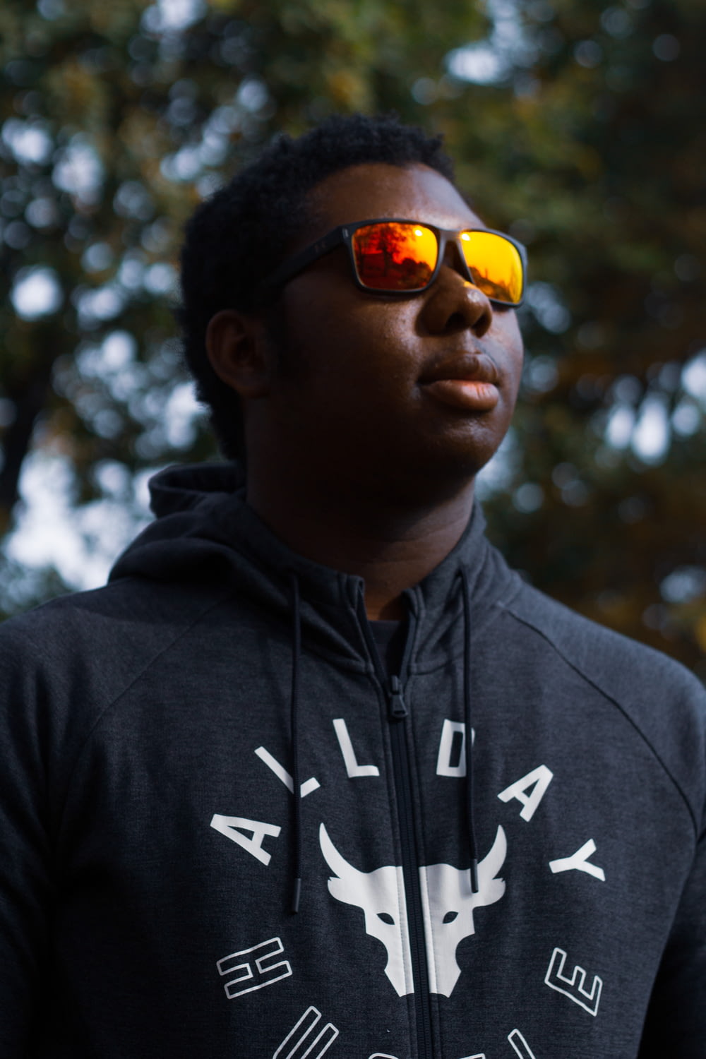man in black and white pullover hoodie wearing yellow sunglasses