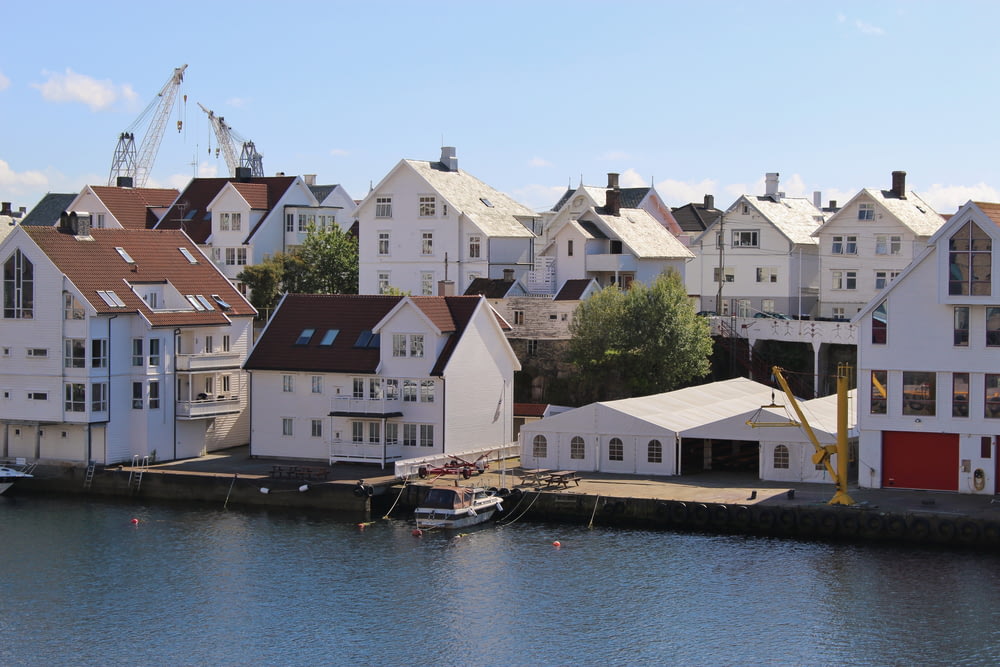 white and brown houses beside body of water during daytime