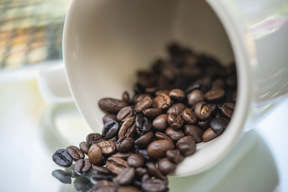 brown coffee beans on white ceramic mug