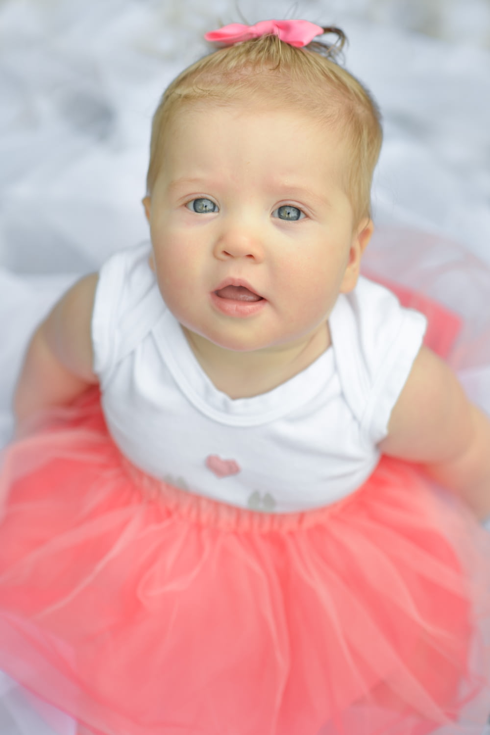 bébé en robe blanche et rose