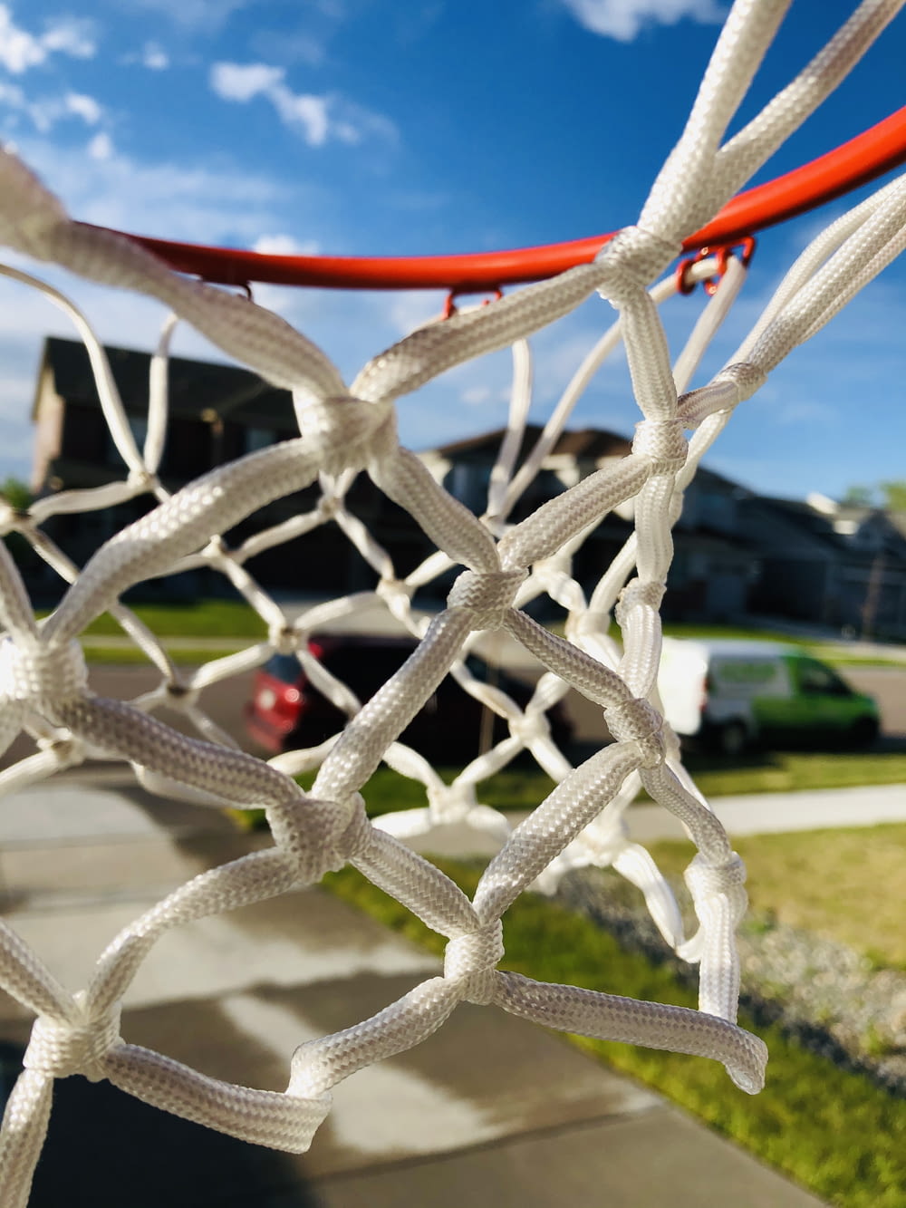 a close up of a basketball net with a house in the background