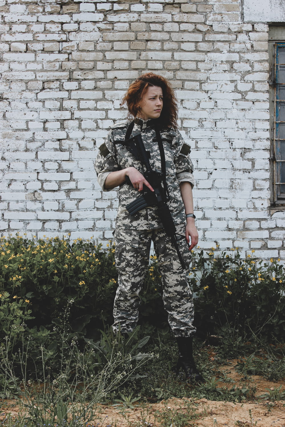 woman in camouflage uniform standing on green grass during daytime