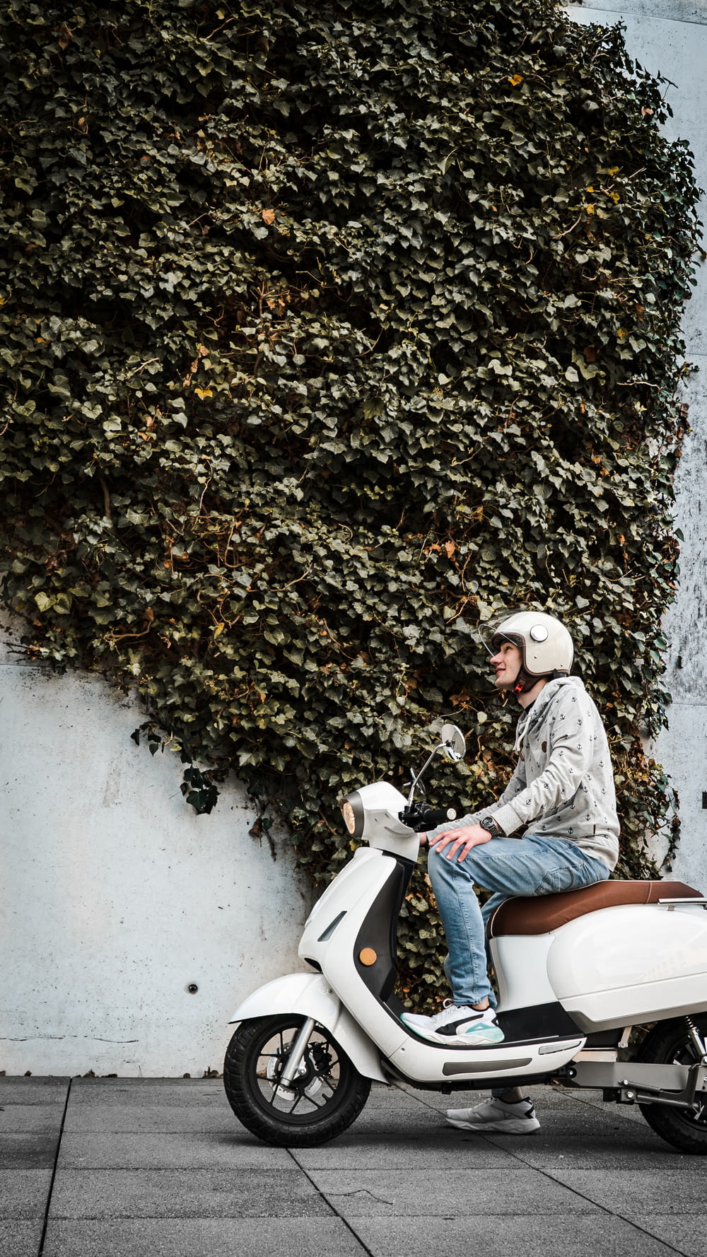 donna in giacca di jeans blu equitazione scooter a motore bianco