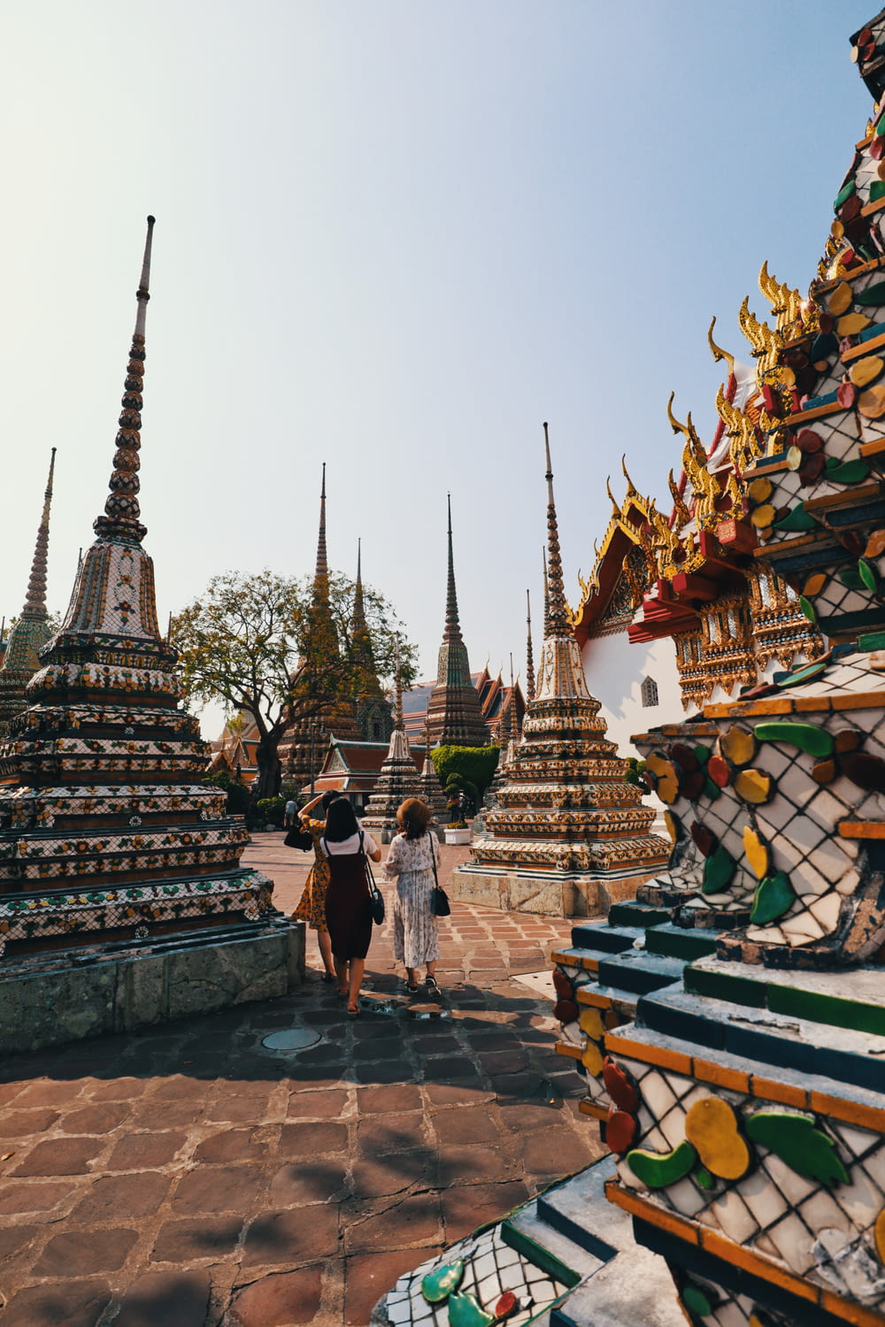 people walking near gold and white temple during daytime
