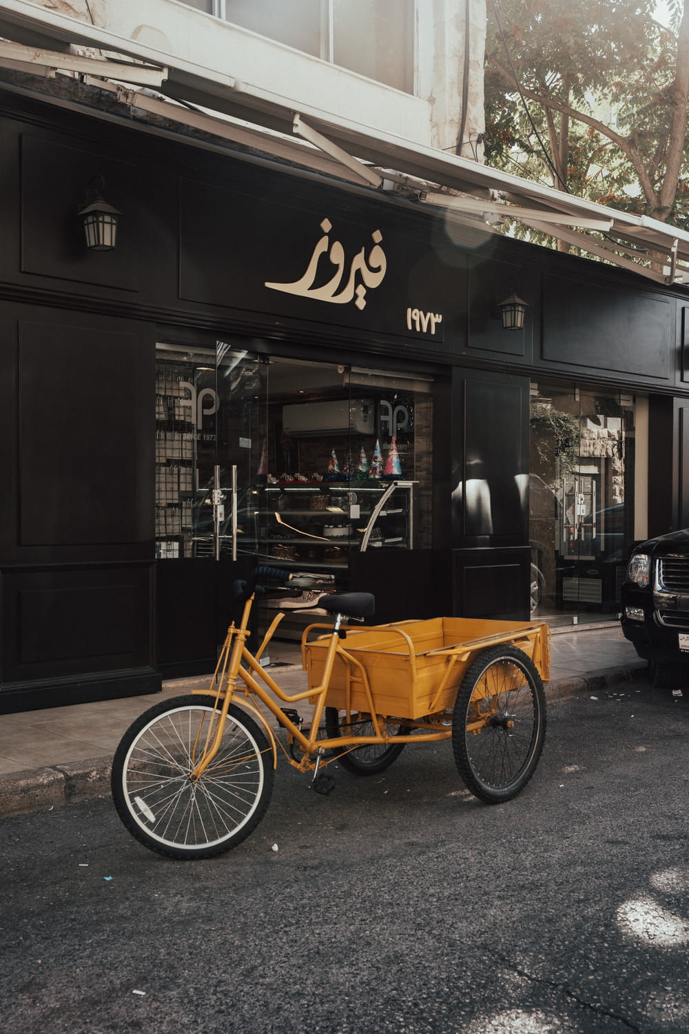 Triciclo nero e marrone parcheggiato accanto al negozio di legno marrone durante il giorno