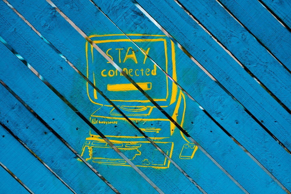 a picture of a blue and yellow sign on a wooden surface