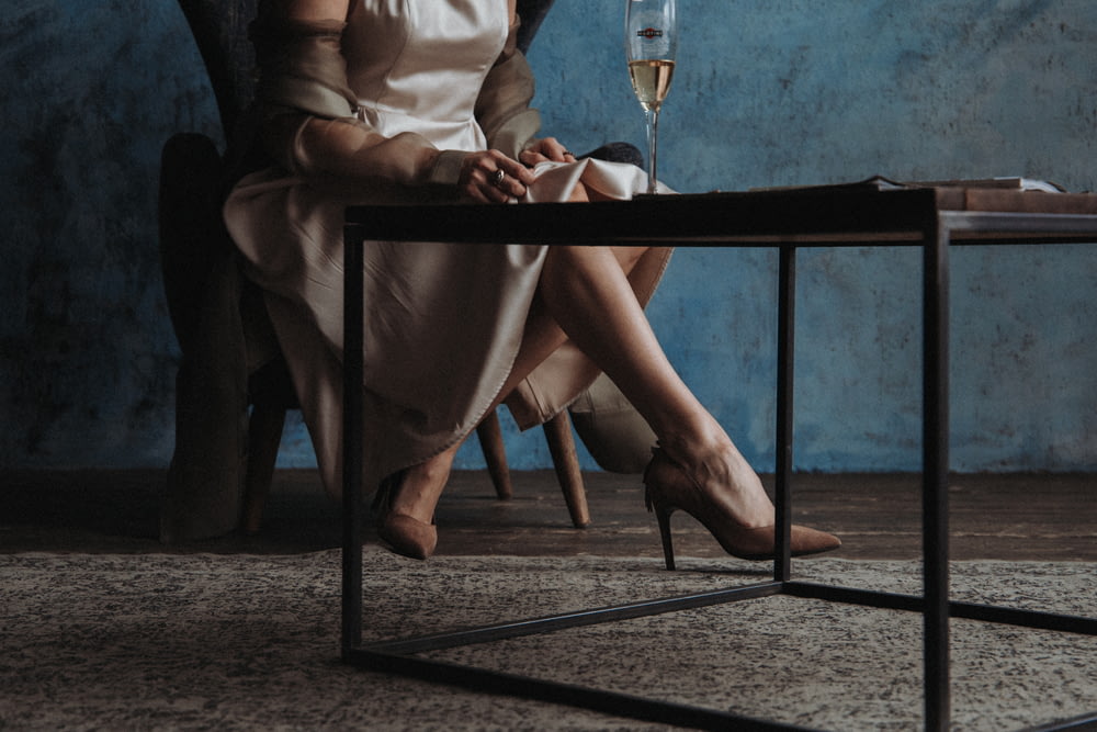woman in white long sleeve shirt sitting on chair holding wine glass