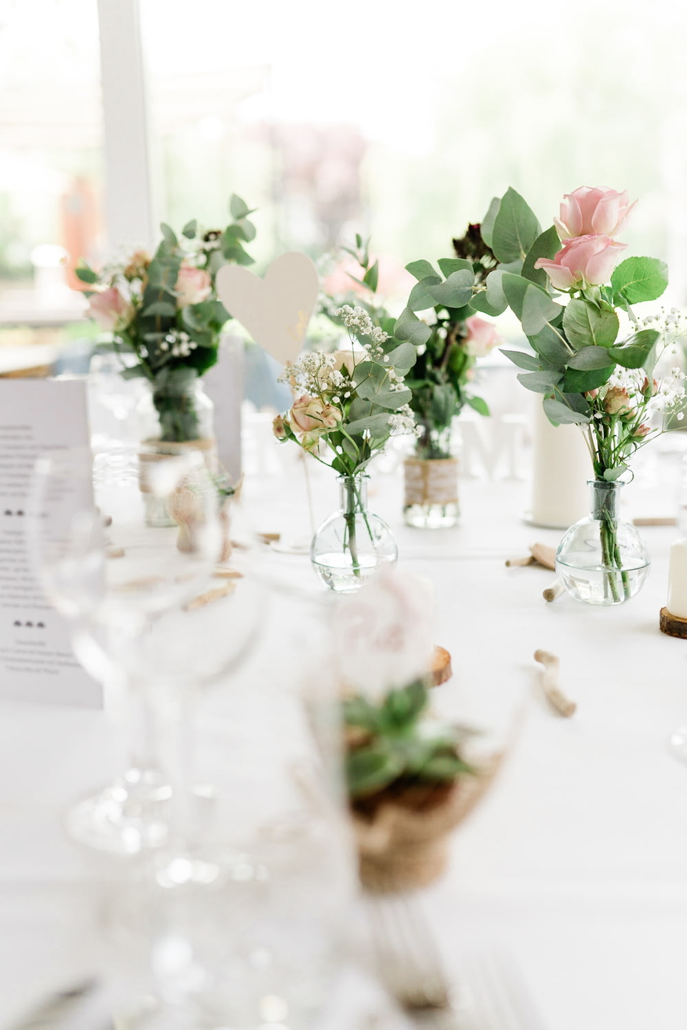 ピンクと白のバラ、テーブルの上の透明なガラスの花瓶