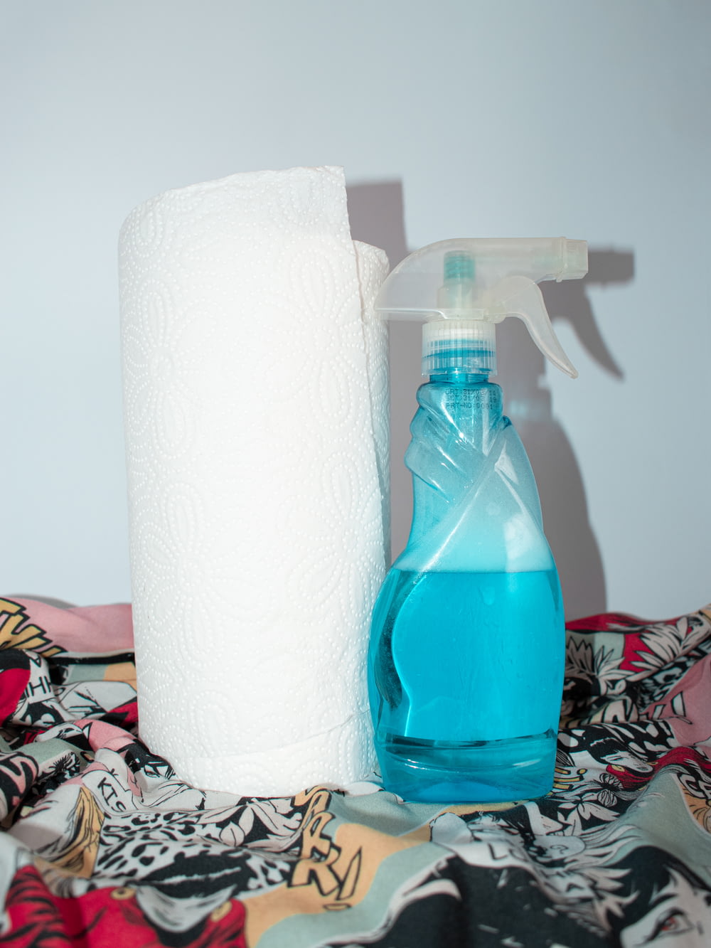 Rouleau de papier de soie blanc à côté d’une bouteille en plastique bleue