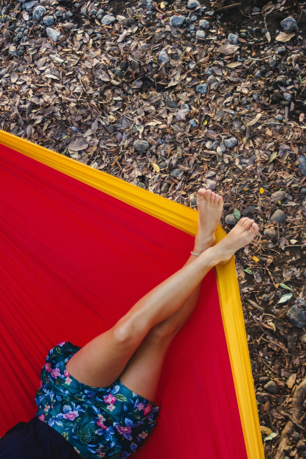 woman in red dress lying on yellow and red hammock