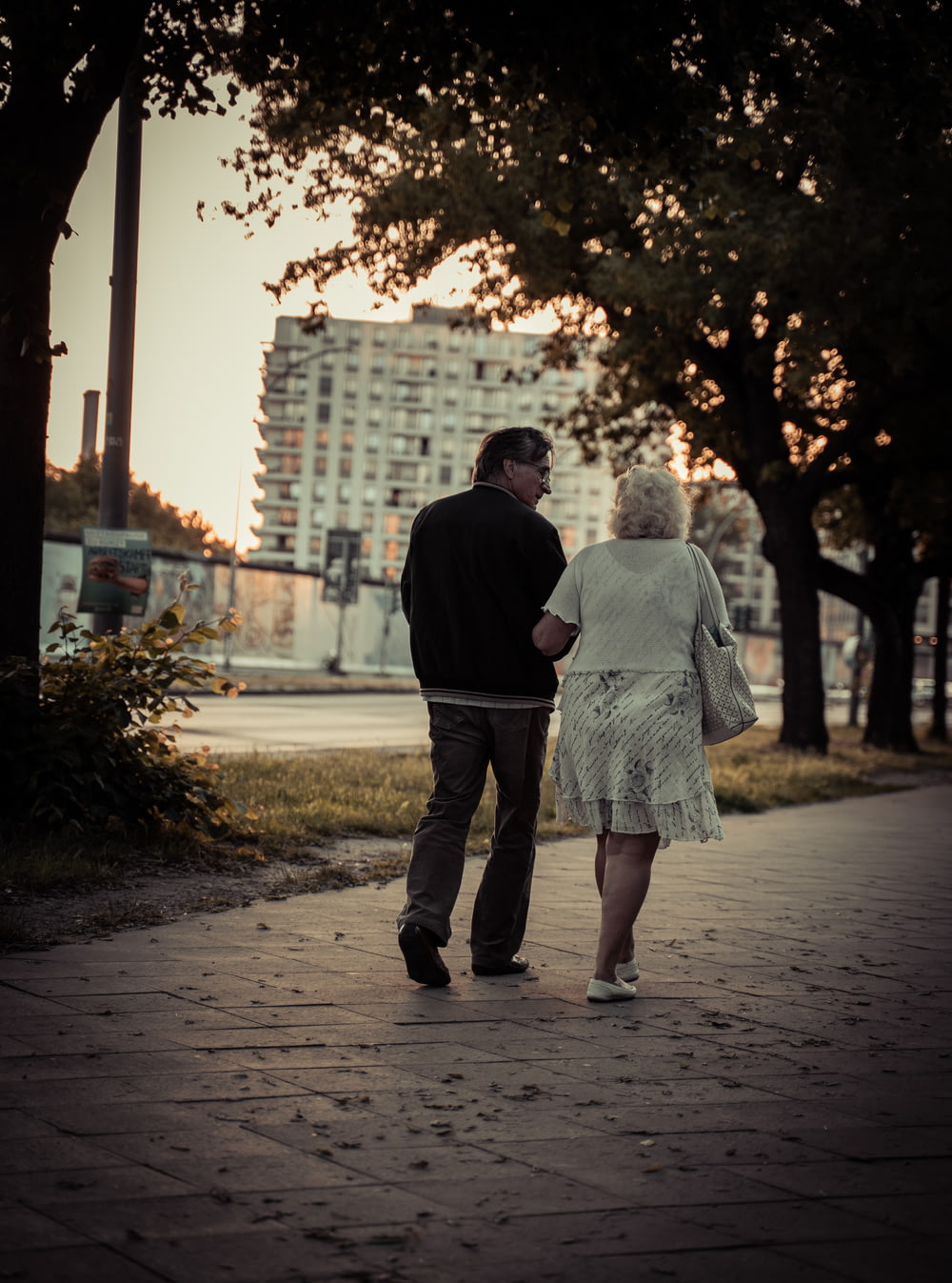 casal andando na calçada durante o dia