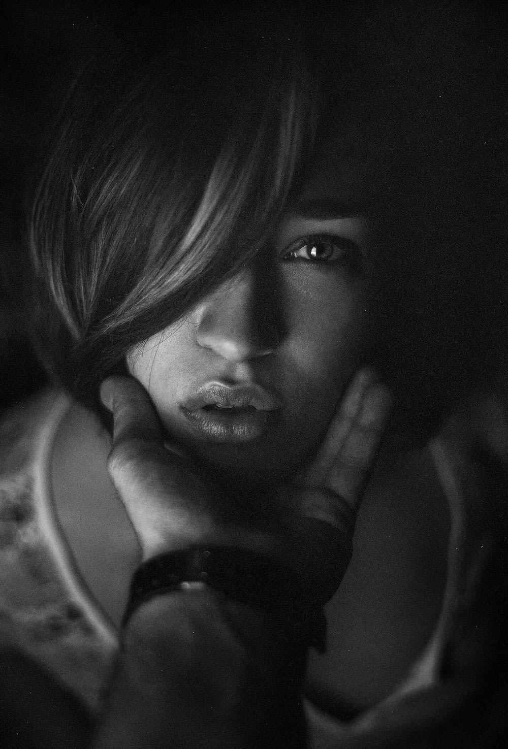 grayscale photo of woman with hand on her face