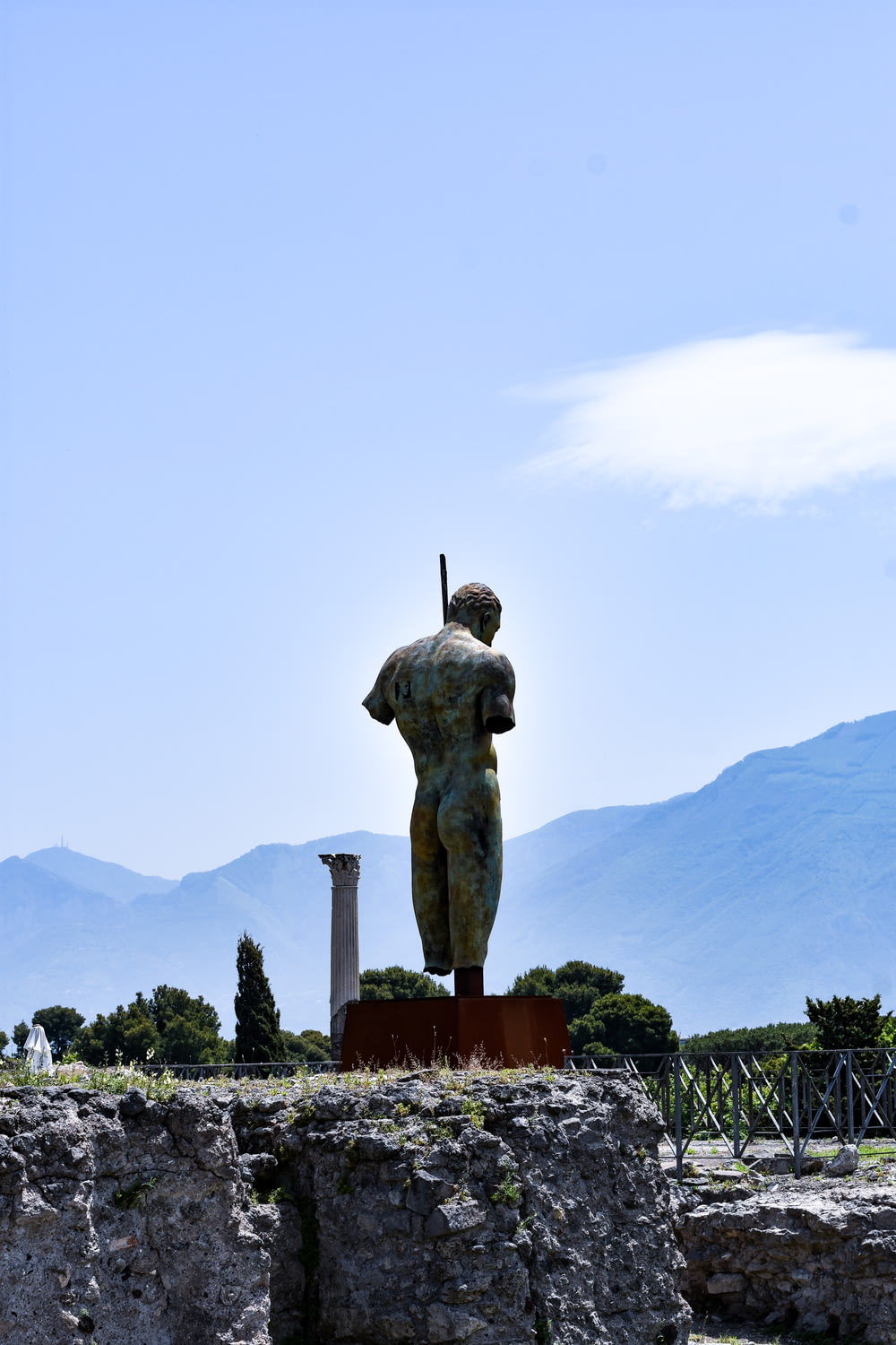 statue of man on top of mountain during daytime