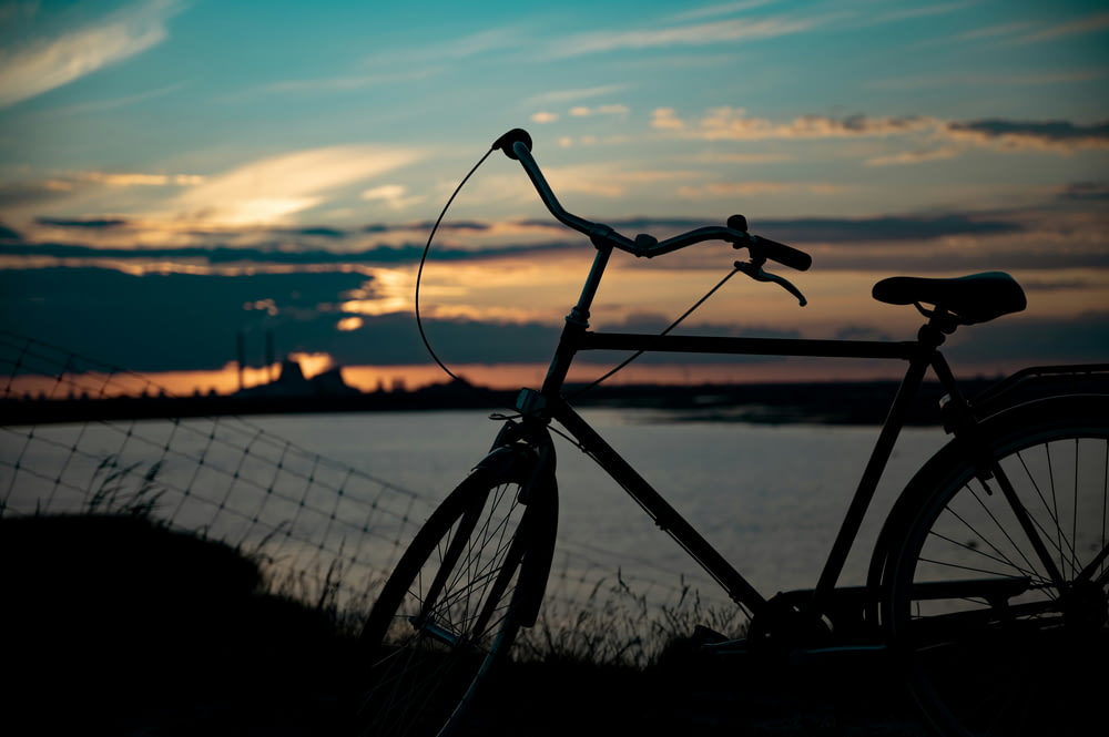 black bicycle on green grass during sunset