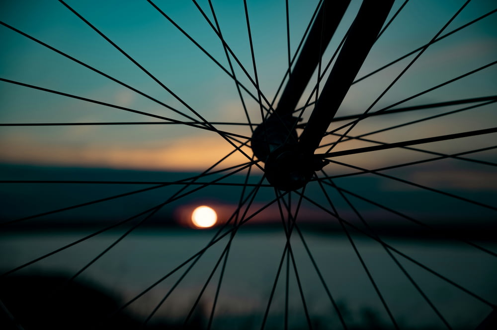Roue de vélo noire au coucher du soleil