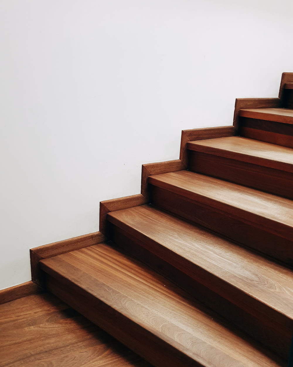 Escalier en bois brun près du mur blanc