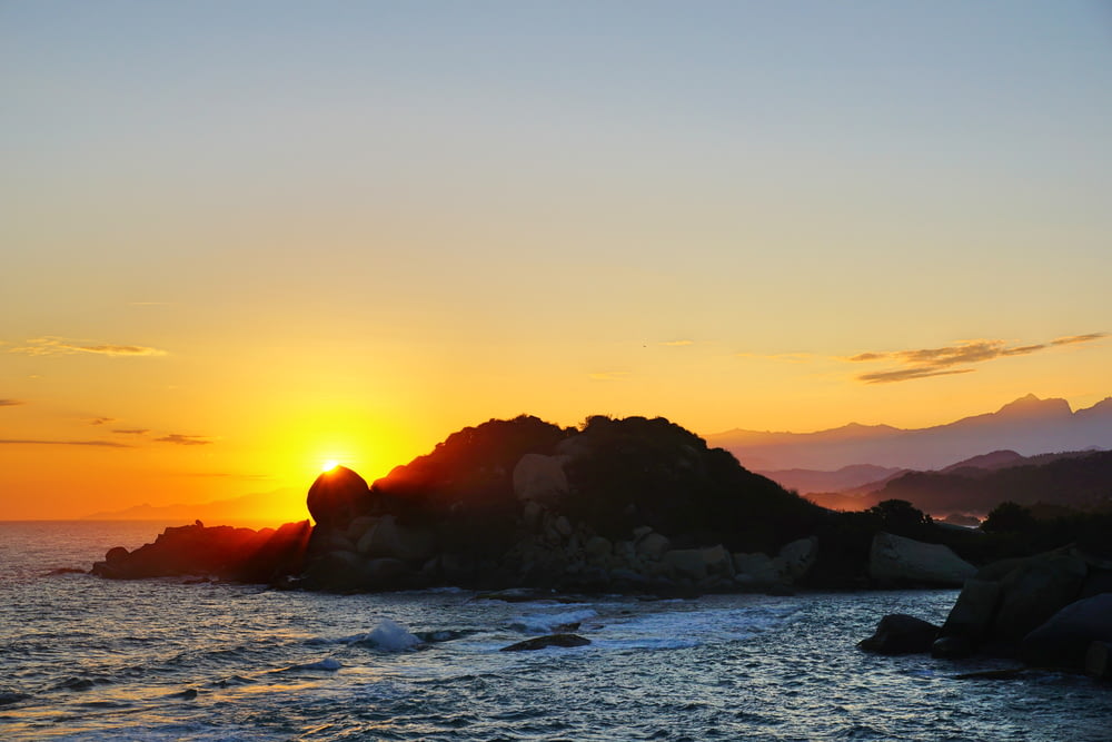 Formation rocheuse noire sur la mer au coucher du soleil