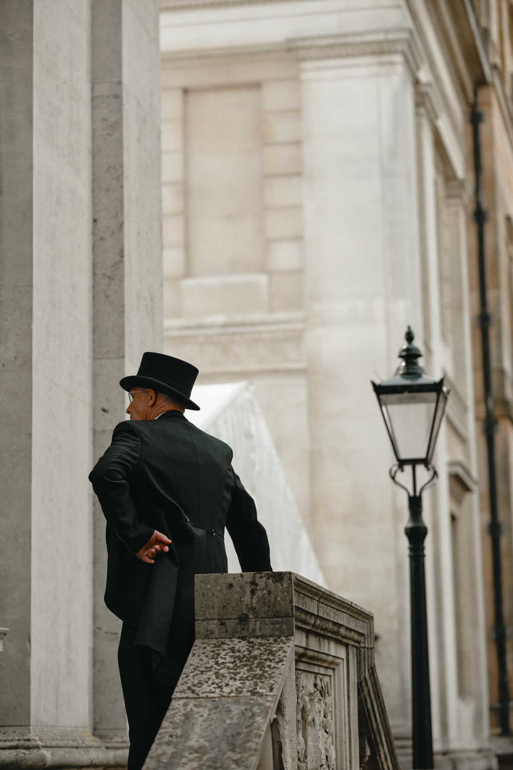 man in black coat standing near black street lamp during daytime