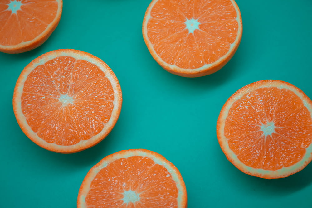 in Scheiben geschnittene Orangenfrüchte auf blauer Oberfläche
