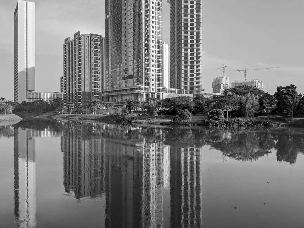 grayscale photo of high rise buildings near body of water